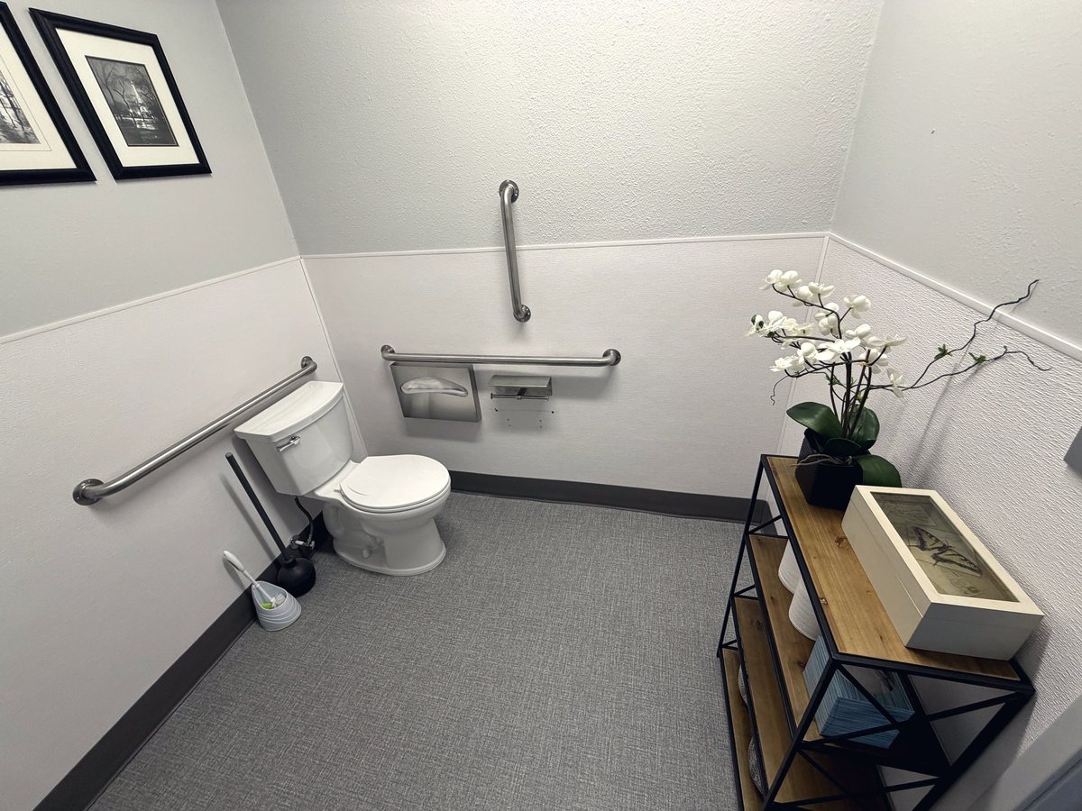 Finished office ADA restroom with grab bars and a floor-mount toilet