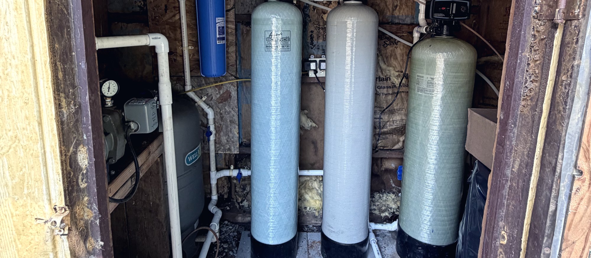 Well water treatment system installed by Beyond Plumbing and Well: pressure tank, sediment filter, media tanks, and water softener